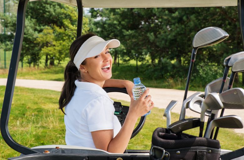 Female in golf cart drinking bottle of water